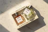 Two perfume bottles from House of Elysian in a box on a marble surface.