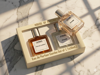 Two Elysius perfume bottles in a box on a marble surface