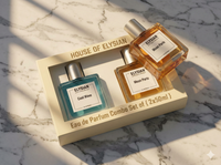 Two Elysian perfume bottles in a box on a marble surface