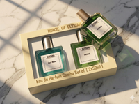 Two Elysiian perfume bottles in a box on a marble surface